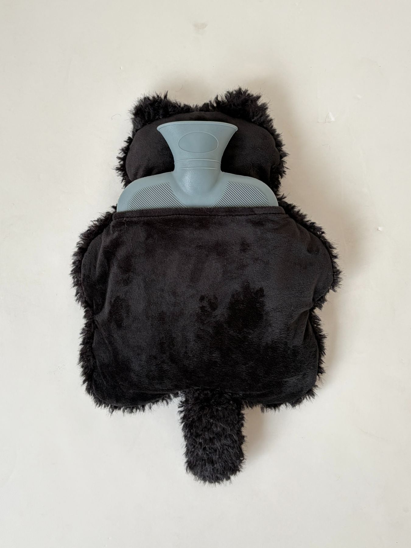 背面のスリットから付属の湯たんぽを出し入れします。湯たんぽは、柔らかく体にフィットしやすい樹脂素材。