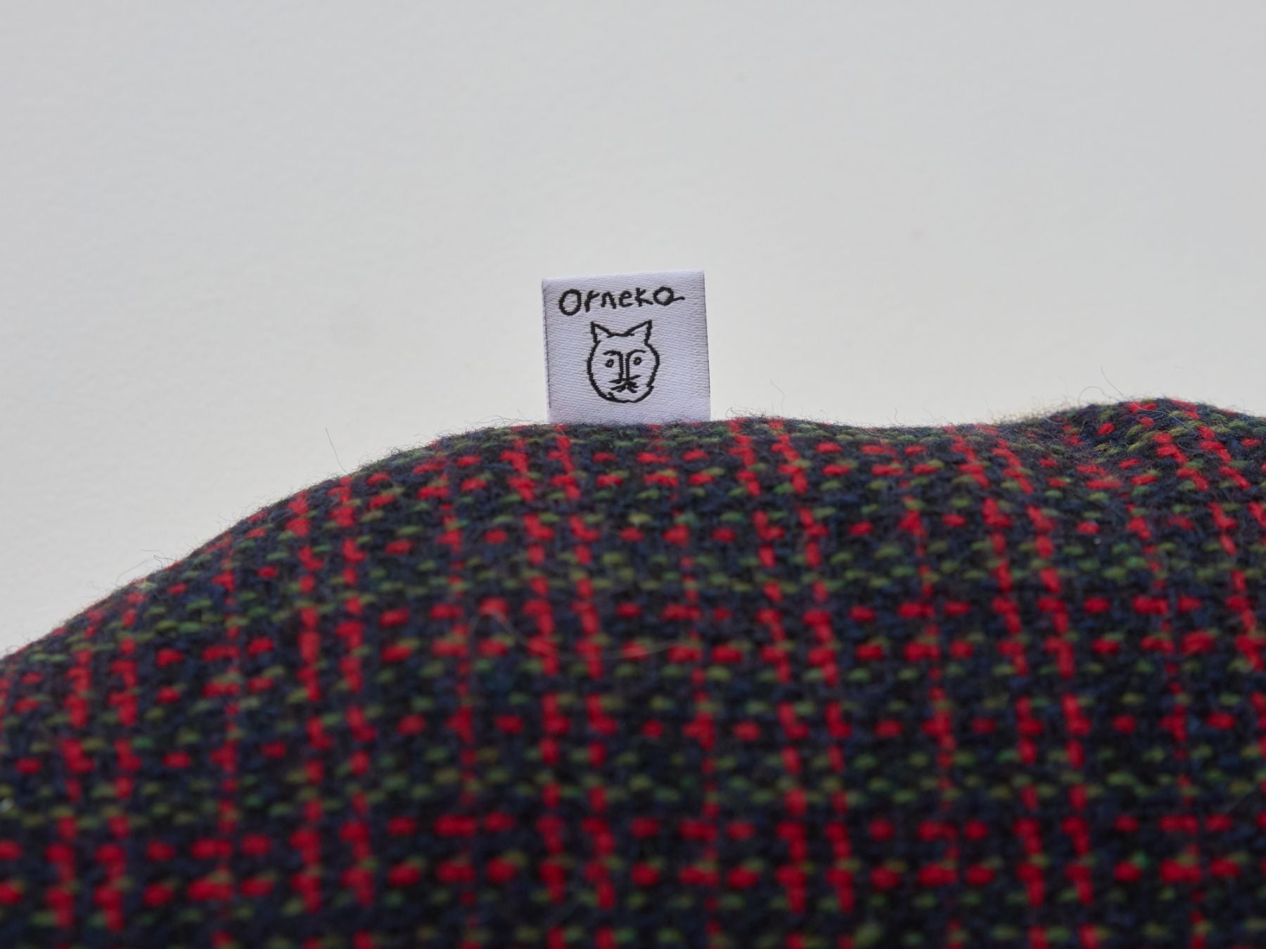 クッションのサイドにオルネコのタグ付き。