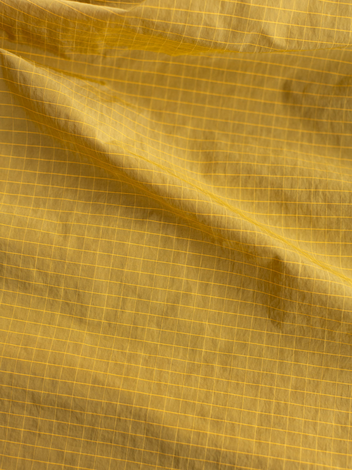 リップストップ生地。<br>
薄くて軽い生地に太い糸を格子状に織り込み、裂けや破れを防ぐ高耐久な機能性素材です。