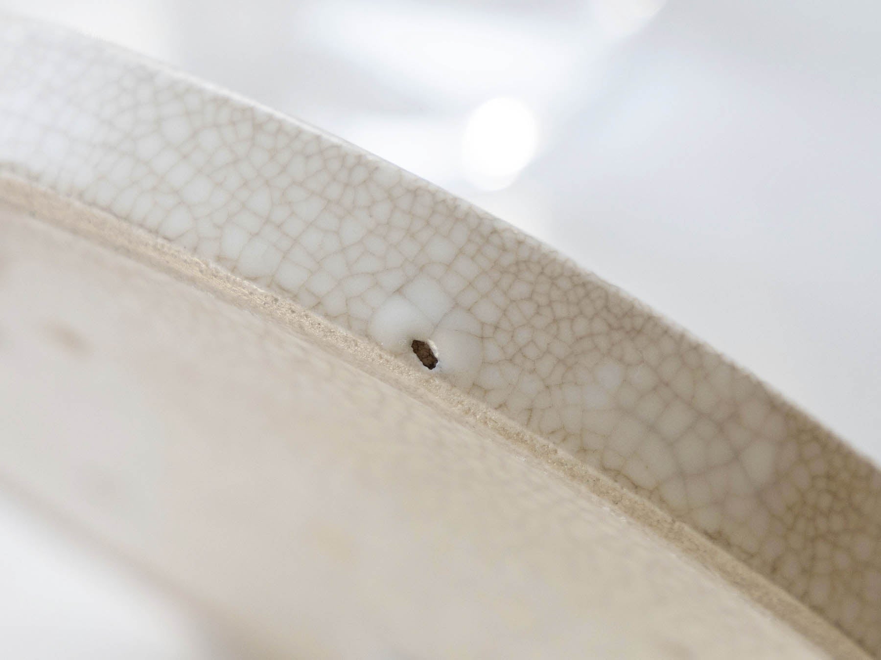 陶磁器の製法の特性でできる穴が、大きく見える場合があります。